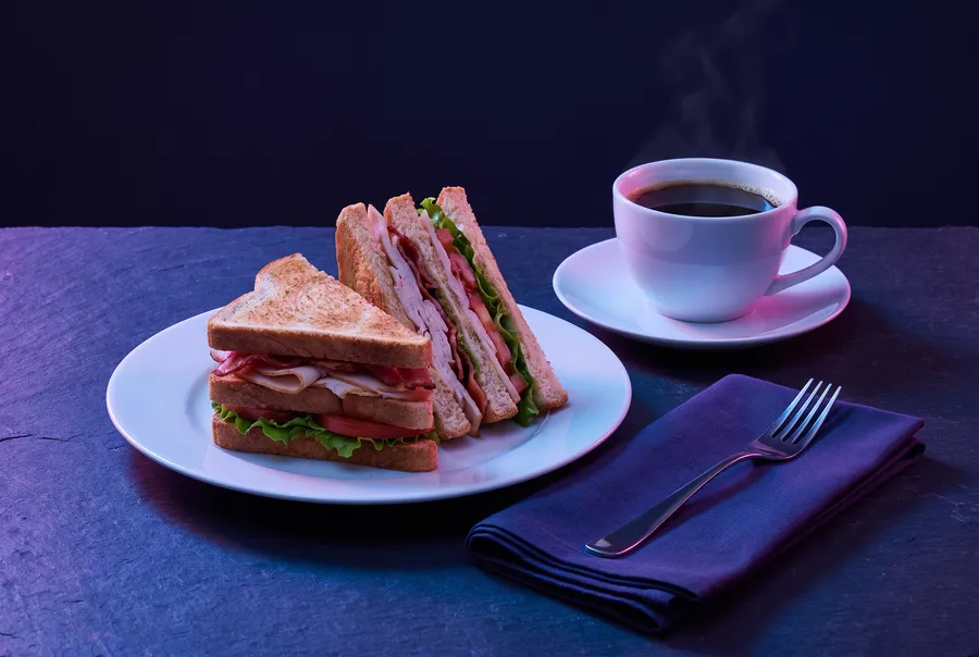 Club sandwich and coffee on dark slate