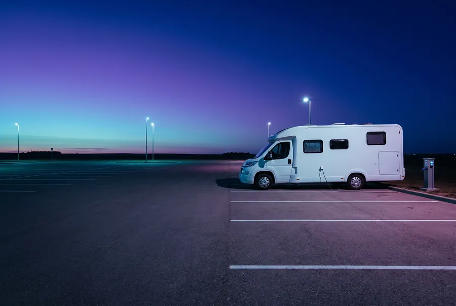Motorhome plugged into a power pedestal at dusk